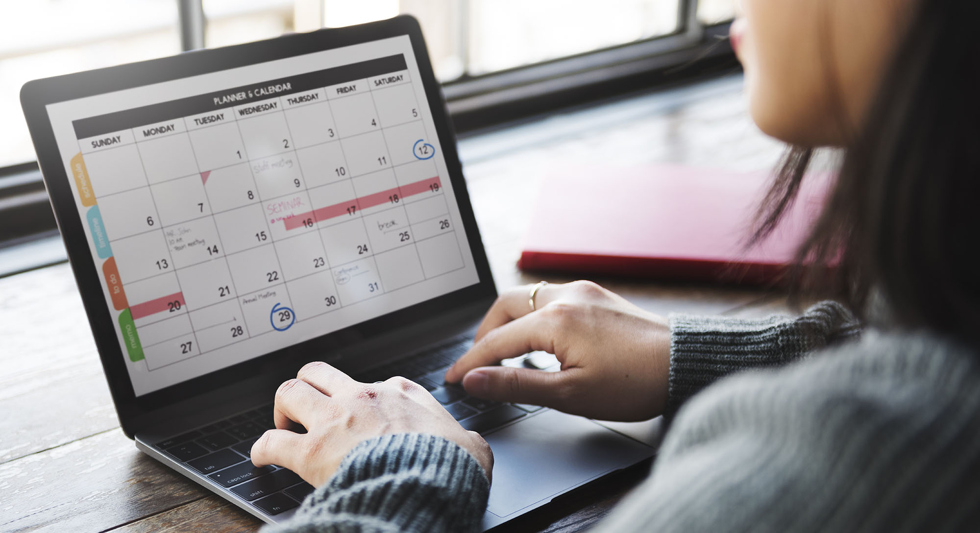 Woman at laptop, looking at events calendar